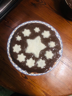 Una foto de Pastel de vainilla cubierto con chocolate y coco