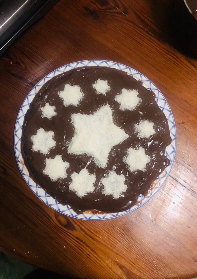 Una foto de Pastel de vainilla cubierto con chocolate y coco