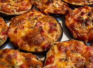 Una foto de Berenpizza: mini pizzas de berenjena con mozzarella, tomate y bacon🧡