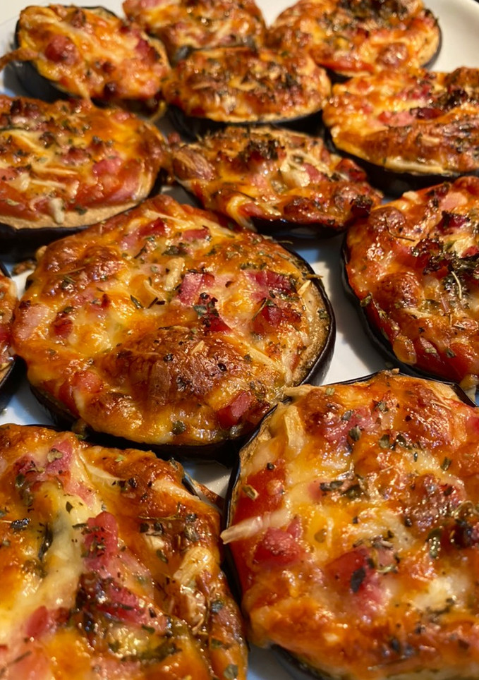 Una foto de Berenpizza: mini pizzas de berenjena con mozzarella, tomate y bacon🧡