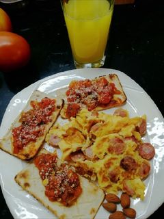 Una foto de Huevos rancheros, tostaditas con tomates y orégano🍳
