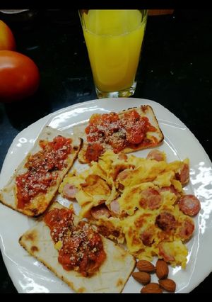 Una foto de Huevos rancheros, tostaditas con tomates y orégano🍳