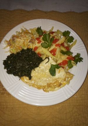 A picture of French fries,served with fried eggs accompanied with greens🤤.