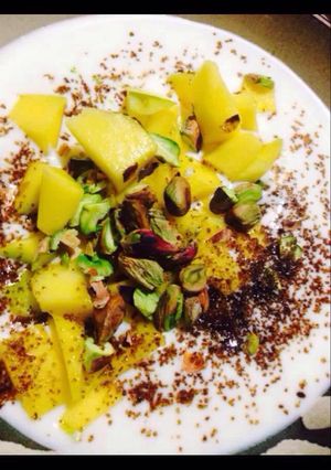 Una foto de Shrikhand de mango azúcar negra y pistachos