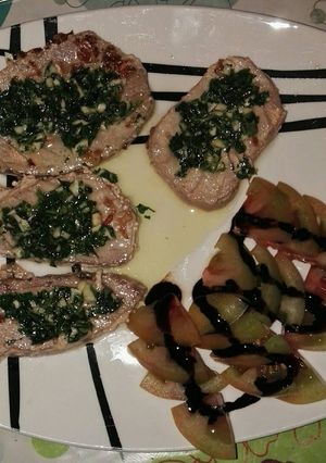 Una foto de Supremas de atún al ajo y perejil con guarnición de tomate