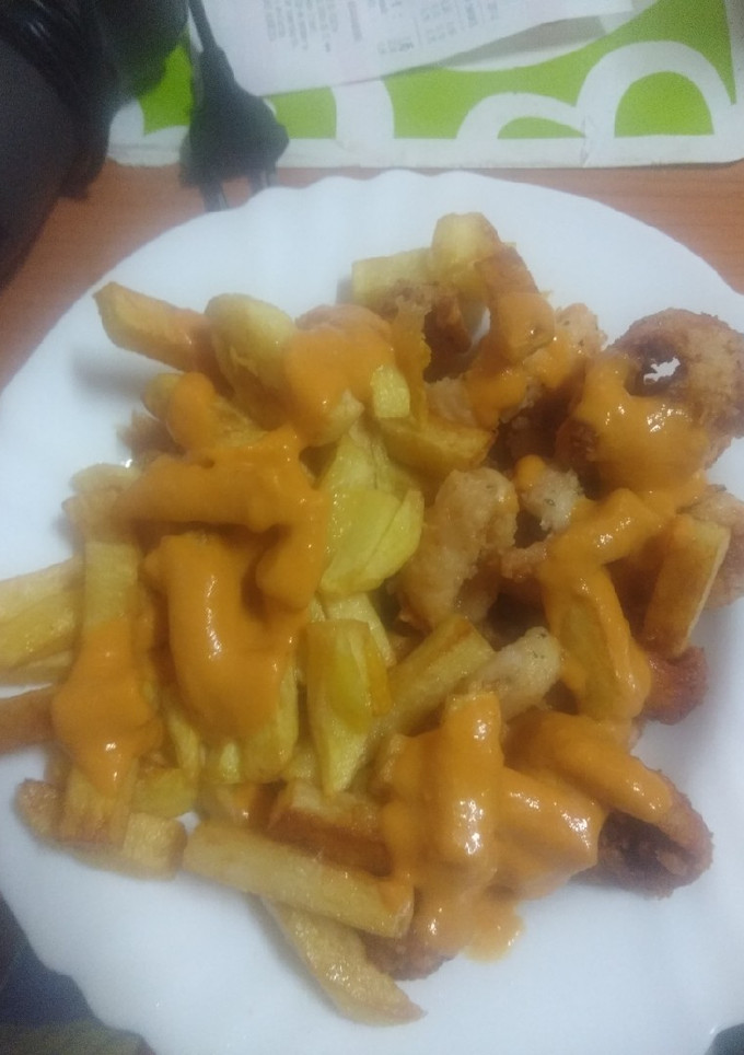 Una foto de Calamares y papas fritas con salsa brava asada