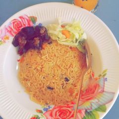 A picture of Jollof rice en spaghetti with fry meat.