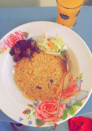 A picture of Jollof rice en spaghetti with fry meat.