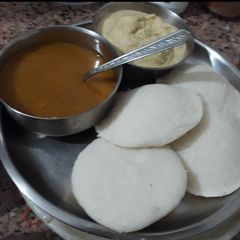 A picture of Rice Idli with coconut chutney and Sambhar.