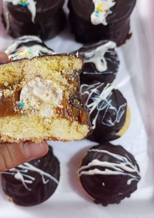 Una foto de Alfajores de Coco Bañados en Chocolate ByN
