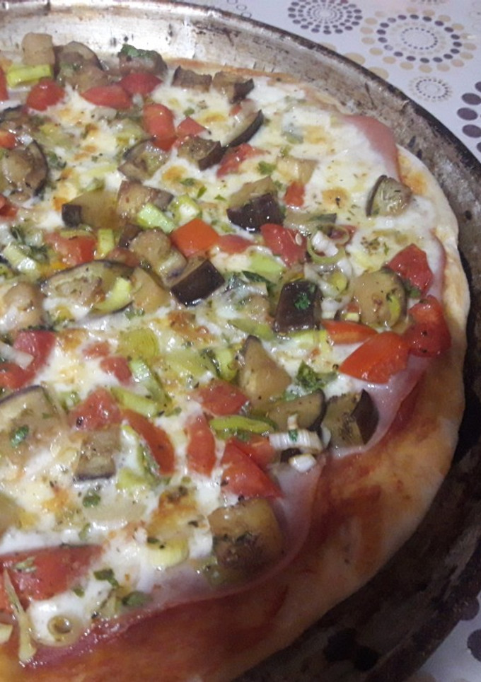 Una foto de Pizza casera de berenjena, tomate y puerro