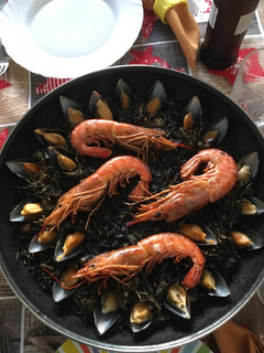 Una foto de Fideuà negra de sepia y gambas