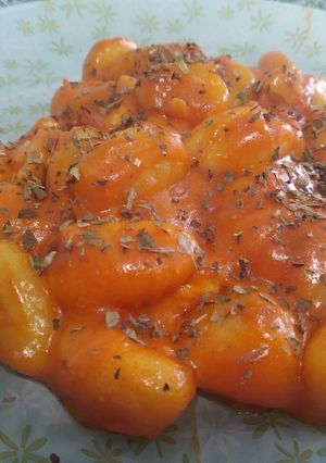 Una foto de Ñoquis con tomate y pollo