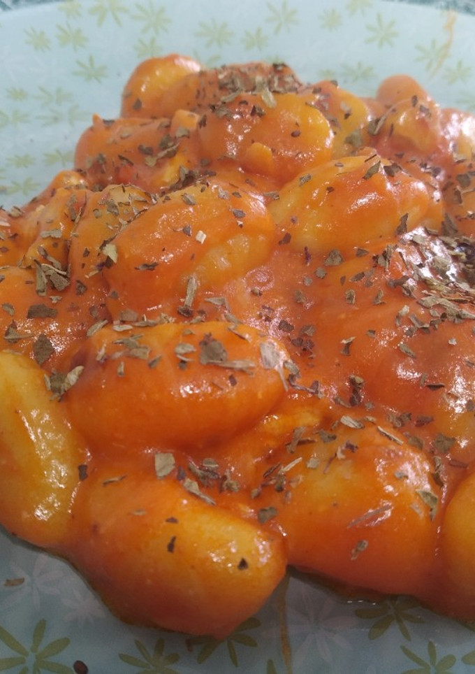 Una foto de Ñoquis con tomate y pollo