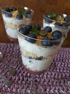 Una foto de Postre de bizcocho, crema y arándanos frescos