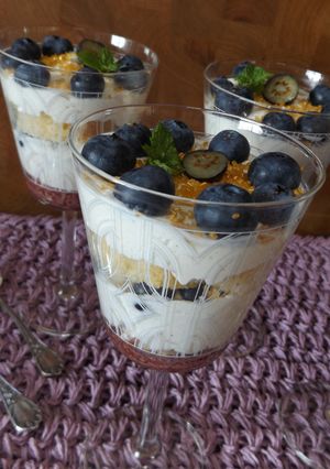 Una foto de Postre de bizcocho, crema y arándanos frescos