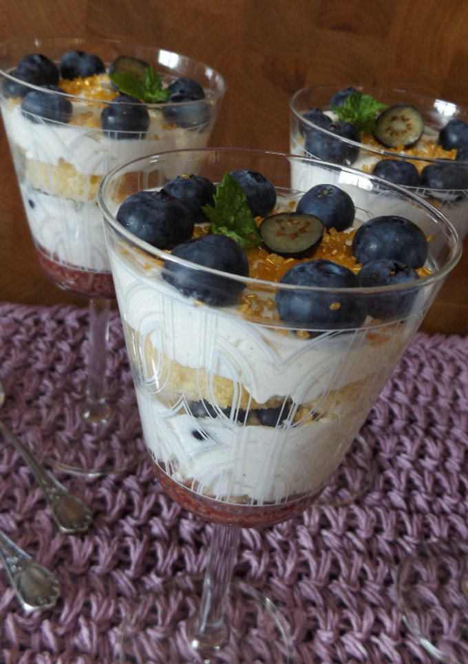 Una foto de Postre de bizcocho, crema y arándanos frescos