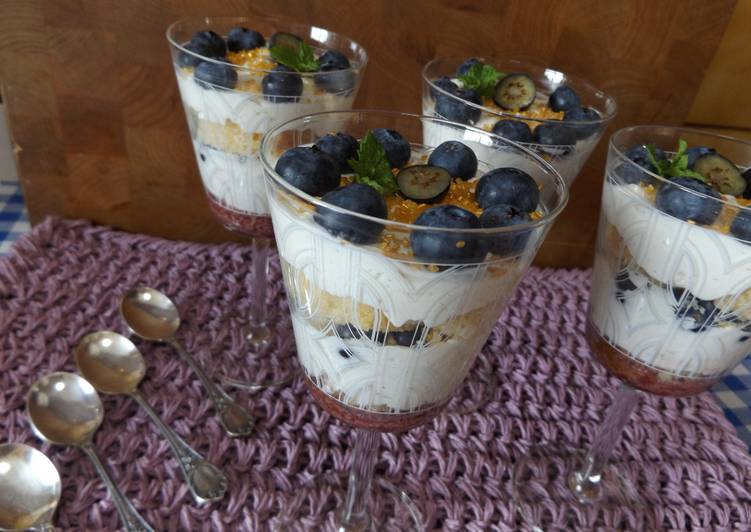 Postre de bizcocho, crema y arándanos frescos