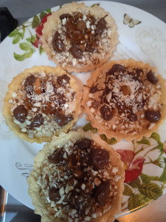 Una foto de Tarteletas de crema pastelera, dulce de leche, almendras, coco y chocolate