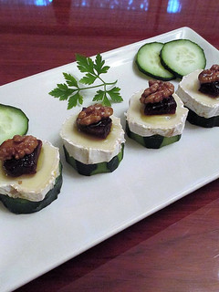 Una foto de Queso de rulo de cabra con membrillo y nueces sobre rodajas de pepinos - tapas