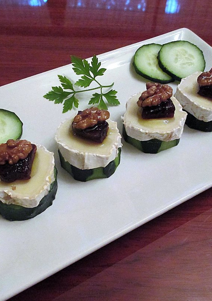 Una foto de Queso de rulo de cabra con membrillo y nueces sobre rodajas de pepinos - tapas