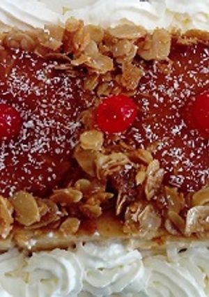 Una foto de Flan de queso con piña, almendras laminadas caramelizadas y nata