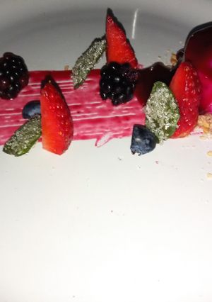 Una foto de Panna cotta de pitaya con Coulis de frutos rojos