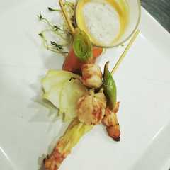 Una foto de Crema de Langostinos, brochette y espuma de coco