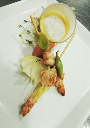 Una foto de Crema de Langostinos, brochette y espuma de coco