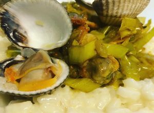 Une photo de Risotto aux coques, poireaux, curry et romarin