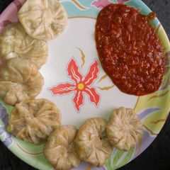 A picture of Momos with Schezwan chutney.