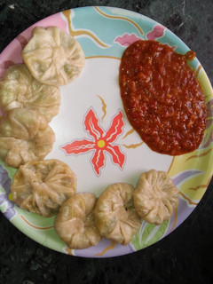 A picture of Momos with Schezwan chutney.