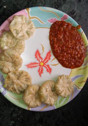 A picture of Momos with Schezwan chutney.