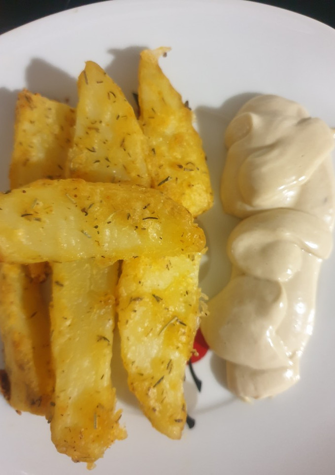 Una foto de Patatas crujientes con especias y mahonesa de ajo negro