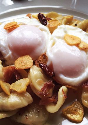 Una foto de Orechietti con chips de ajo guindilla y huevo poche