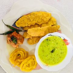 A picture of Fafda, jalebi with chutney and salad.