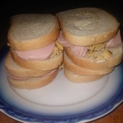 A picture of Homemade sandwich with mushroom eggs and salami.