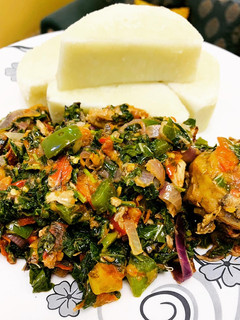 A picture of Yam n spinach sauce with smoked chicken and fish.