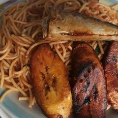Jollof Spaghetti with fried plantain and fish A picture of Jollof Spaghetti with fried plantain and fish.