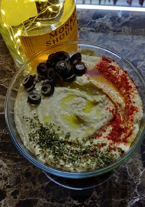 A picture of Hummus with soda cracker.