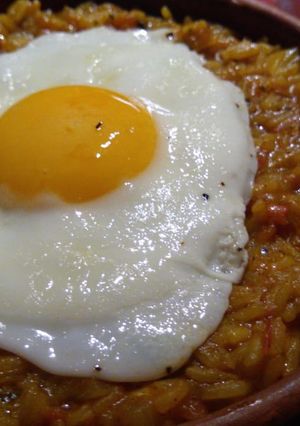 Una foto de Cocina en crisis: Guiso de arroz amarillo coronado con 1 huevo