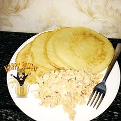 A picture of Pancakes with scrambled eggs and sausage.