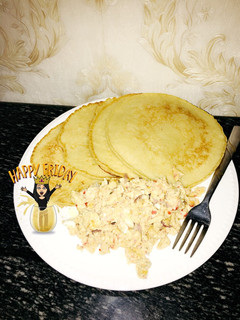 A picture of Pancakes with scrambled eggs and sausage.