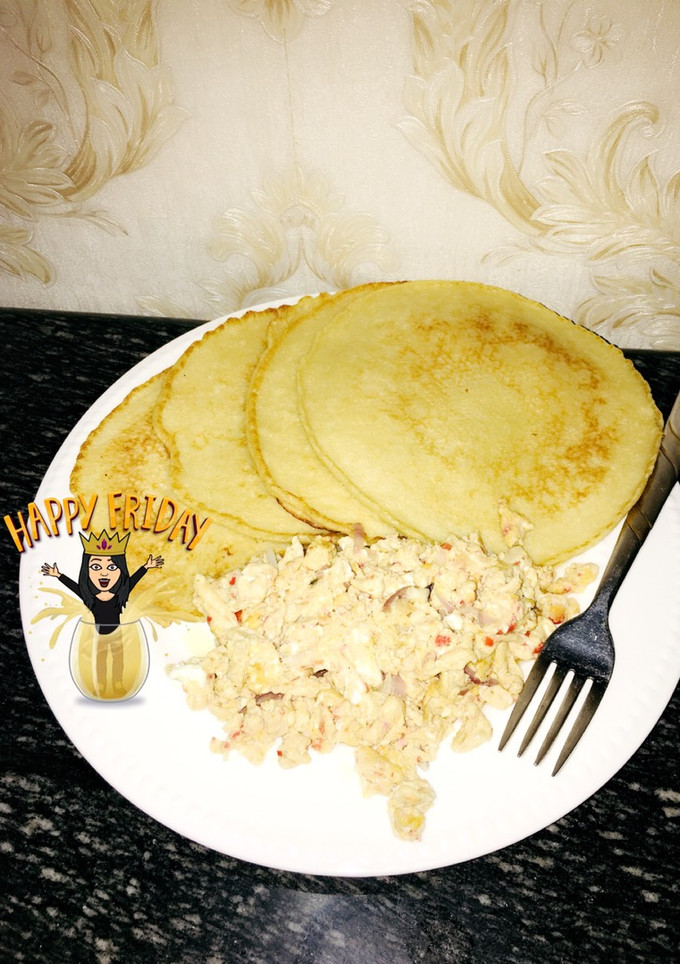 A picture of Pancakes with scrambled eggs and sausage.