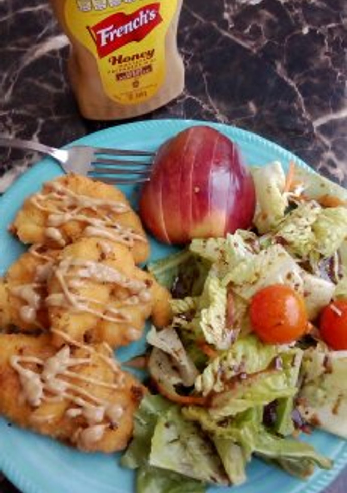 Una foto de Tenders de pollo, ensalada, aderezo honey mustard