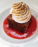 Brownie de avellanas con salsa de fresas y merengue