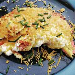 A picture of Sunday breakfast omelet with ham and cheese and chives.