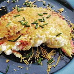 A picture of Sunday breakfast omelet with ham and cheese and chives.