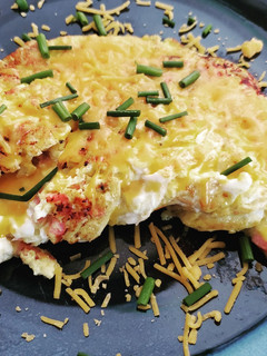 A picture of Sunday breakfast omelet with ham and cheese and chives.