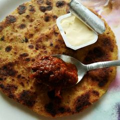 A picture of Makkai ka paratha stuffed with Paneer and coriander.